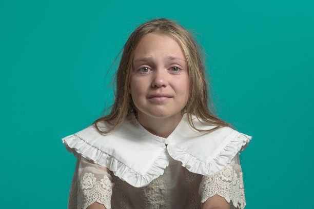 女孩在哭。绿色背景的特写图片下载