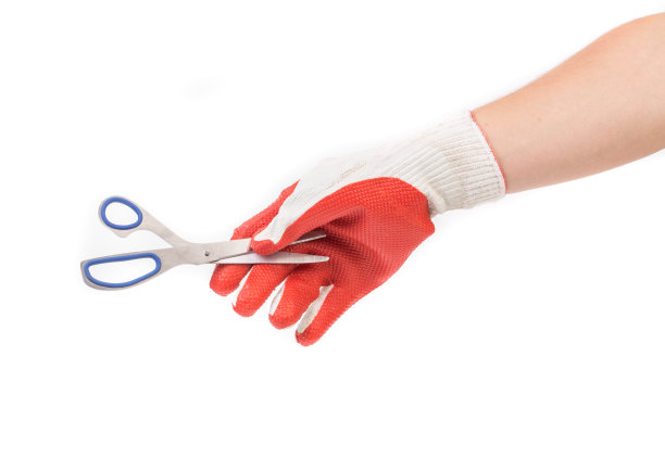 一只戴着手套的手拿着剪刀。图片下载