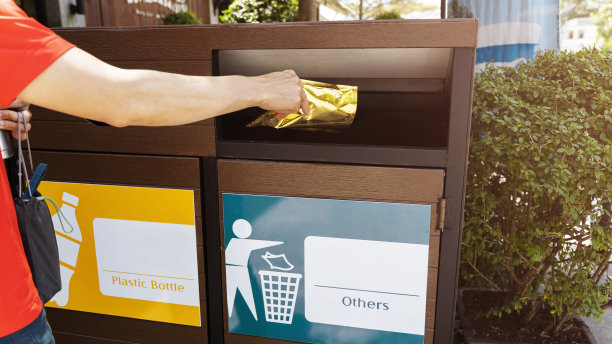 在公园外面的垃圾桶的男人手掉的特写，皱巴巴的塑料可以回收到篮子里。垃圾,废物图片下载