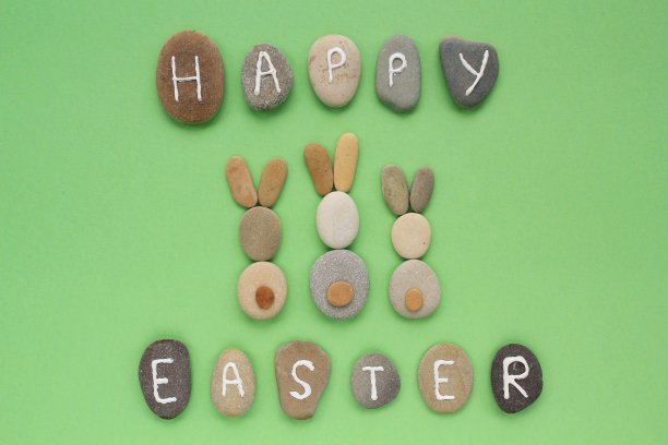 快乐的复活节字母和兔子从鹅卵石在绿色的背景图片下载