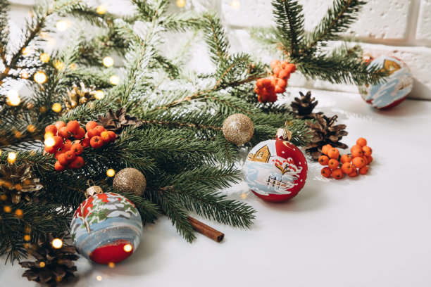 新年，圣诞背景。新年的装饰在一个白色的背景与绿色的圣诞树的树枝灯图片下载