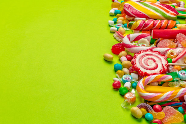 绿色背景上的彩色糖果图片下载