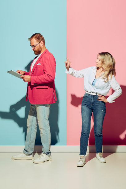 情绪化的年轻夫妇，大胡子的男人和漂亮的女人孤立在蓝粉色的工作室背景。人的情感、青春、爱和积极的生活方式观念图片下载