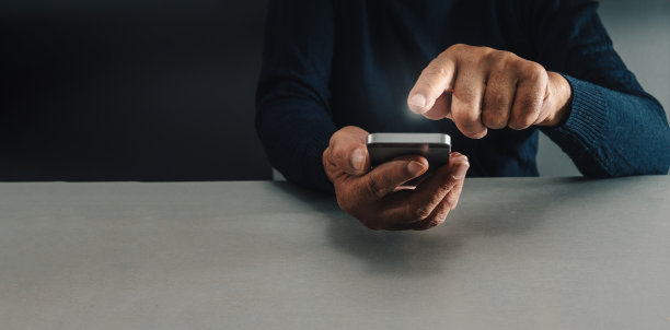 男子拿着手机，试图决定在网上买什么，概念强迫性购物或购物狂图片下载