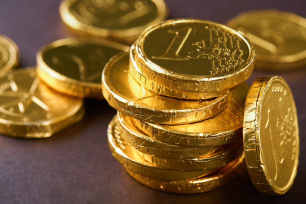 巧克力的硬币。背景巧克力欧元硬币钱的棕色背景。欧元硬币以不同的位置堆叠在一起。的硬币。模拟。图片下载