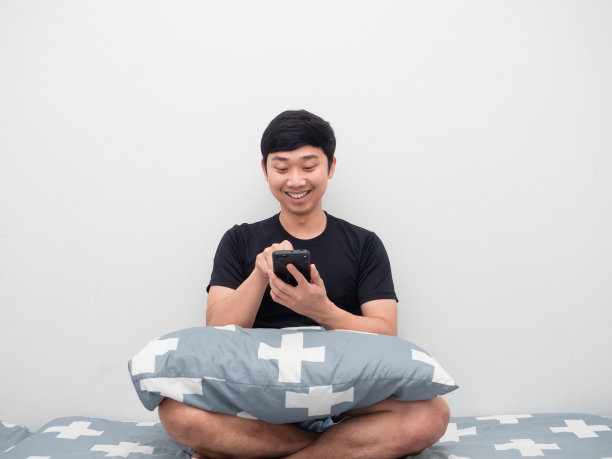 男人坐在床上用手机图片下载