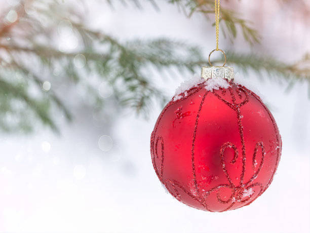 圣诞树上挂着红色的圣诞装饰球，树枝上挂着雪花。图片下载