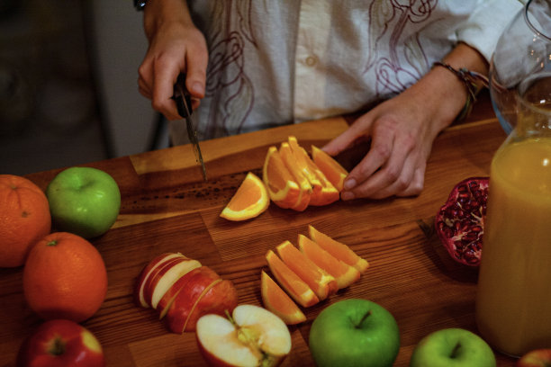 年轻女子切水果做果汁图片下载