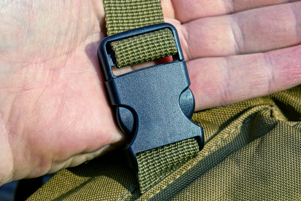 手握绿色系带上的黑色塑料钩环图片下载