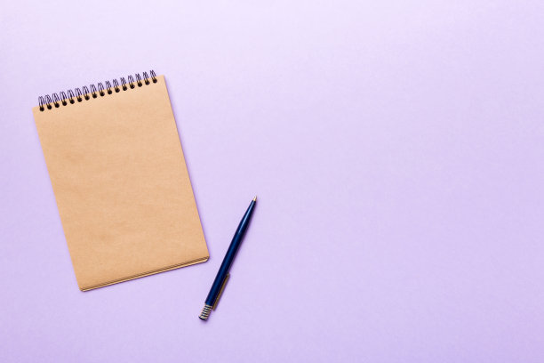 学校棕色笔记本上的彩色背景，螺旋工艺记事本上的桌面视图图片下载