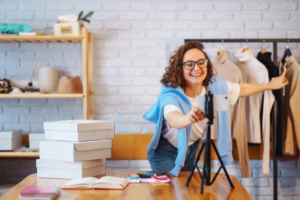 年轻的女博主与粉丝交谈，为vlog直播录制新的时尚视频。图片下载