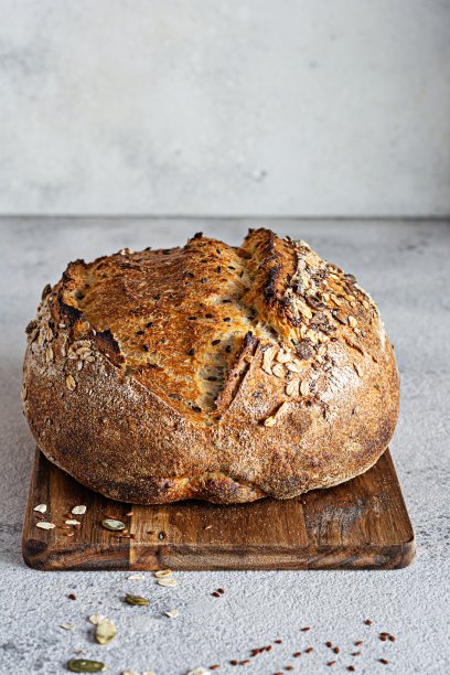 新鲜的自制面包(切片)由全谷物酸面团面粉添加麸皮，种子(向日葵，南瓜，亚麻，芝麻)和燕麦片。健康食品。高质量的照片。图片下载