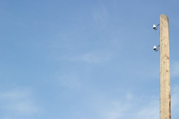 照片，电线杆对着平静的蓝天。图片下载