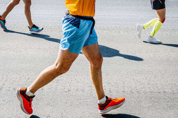 三个跑步者在路上赛跑的腿图片下载
