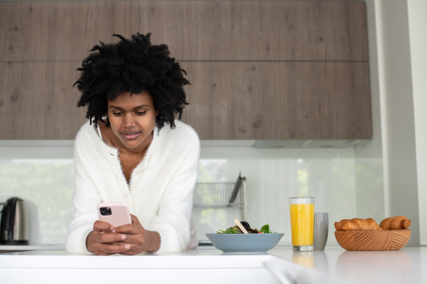 年轻女性在家工作，在智能手机上打字图片下载