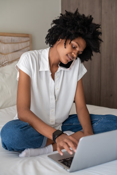 女商人在家里打电话和使用笔记本电脑图片下载