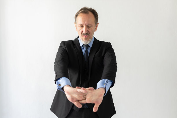 成熟的商人在工作前伸展手臂的画像图片下载