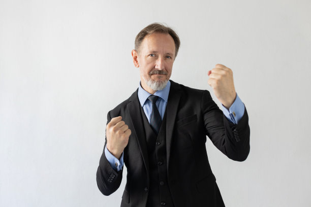 自信的成熟商人用拳头打架的形象图片下载