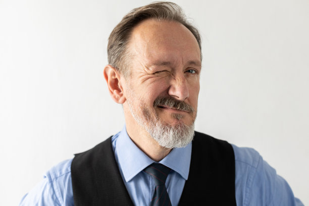 正面成熟商人眨眼的特写图片下载