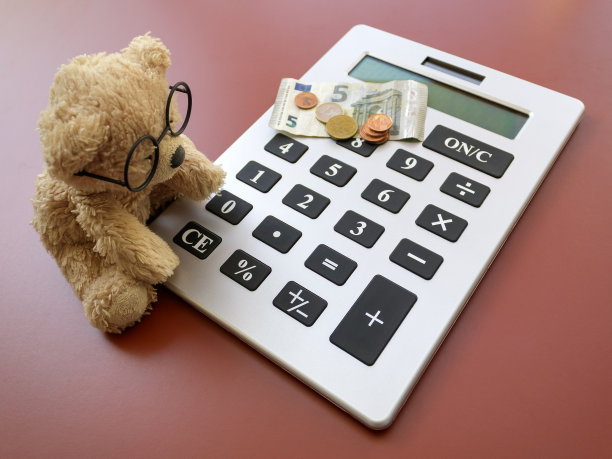 泰迪熊坐在计算器旁边图片下载