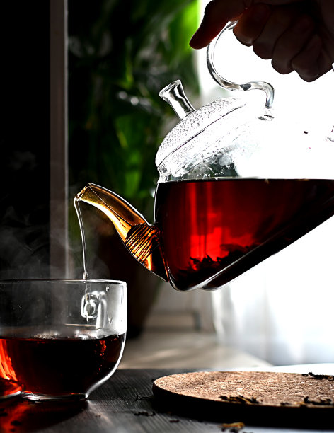 一个女人的手正在往杯子里倒茶。清茶，早茶，家的舒适图片下载