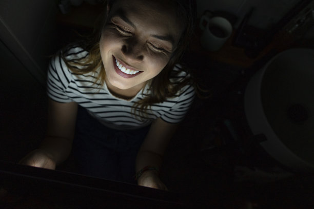 一位拉丁妇女在舒适的家里全神贯注地看着平板电脑上的剧集图片下载