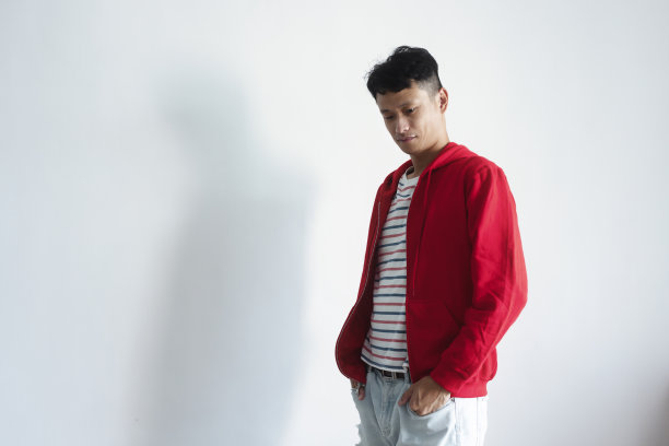 深色的亚洲人在红色夹克的视觉姿势在白色背景。图片下载