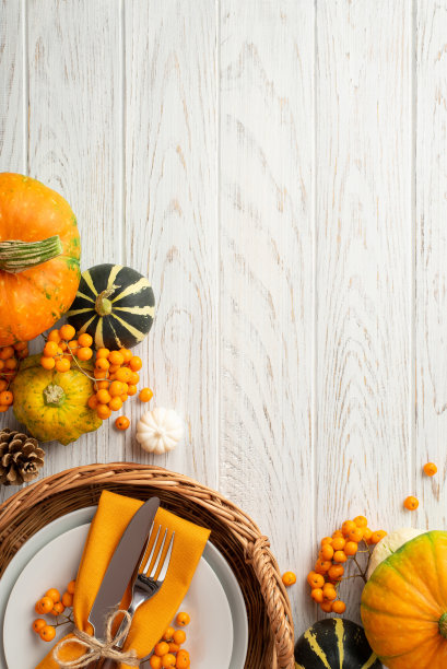 感恩节的概念。顶视图垂直照片藤托盘与盘刀叉餐巾南瓜pattypan松果和rowan浆果孤立的白色木桌背景与复制空间图片下载