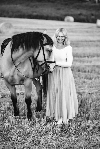 一个女人牵着马散步。一匹在田里的马。骑师和他的宠物图片下载