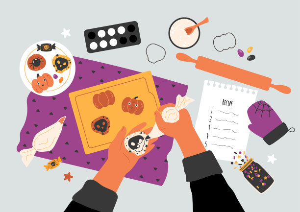 万圣节烘焙概念。手拿着饼干，在头骨上涂上奶油。图片下载