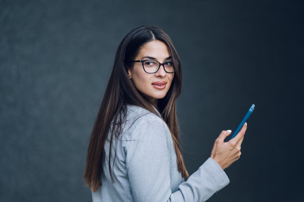 商业女性站在办公楼外使用智能手机图片下载