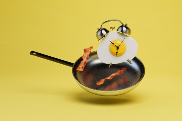 一只煎锅里有香肠，一只黄色背景上有炒鸡蛋的闹钟。三维渲染图片下载