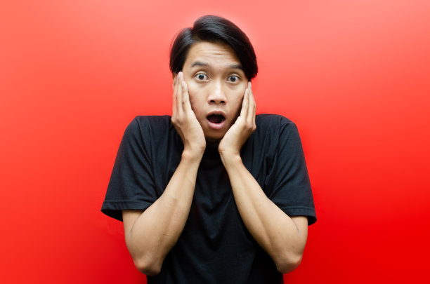 被吓坏的亚洲人捂住嘴，浑身发抖。图片下载