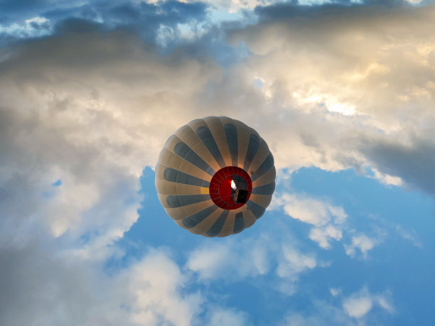 五颜六色的热气球在云层上空飞行。图片下载