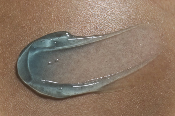 将凝胶血清涂抹在人体皮肤背景上。图片下载