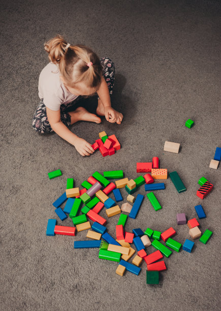 漂亮的小女婴在地板上玩小木块图片下载