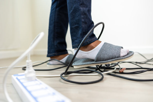 一名男子无意中发现一根杂乱的电线躺在地上。跌跌撞撞，直到头撞到地上。家中事故由于粗心和笨拙触电图片下载