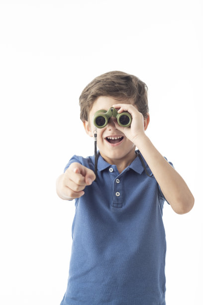 用白色背景的双筒望远镜的孩子。图片下载