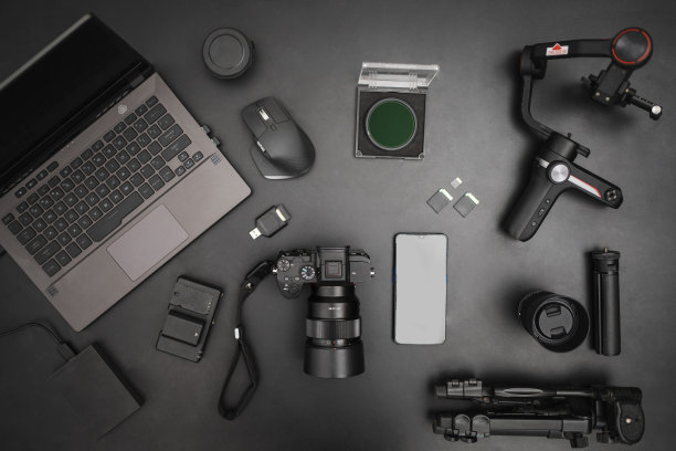 工作场所顶视图摄像设置与笔记本电脑，相机，gimball，三脚架，镜头，电池。俯视图图片下载