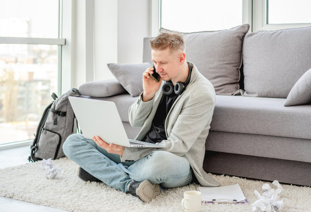 微笑的男人在家里工作图片下载