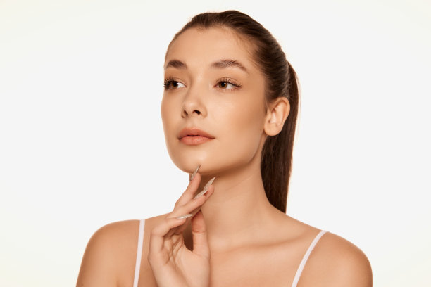 肖像年轻美丽的女人与清澈无暇的皮肤隔离在白色的背景。天然化妆品保健图片下载