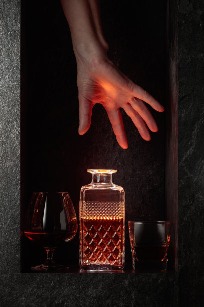 手拿一瓶烈性酒精饮料。图片下载