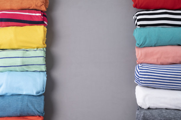 特写卷彩色t恤衣服上灰色的桌子背景，旅行的概念图片下载