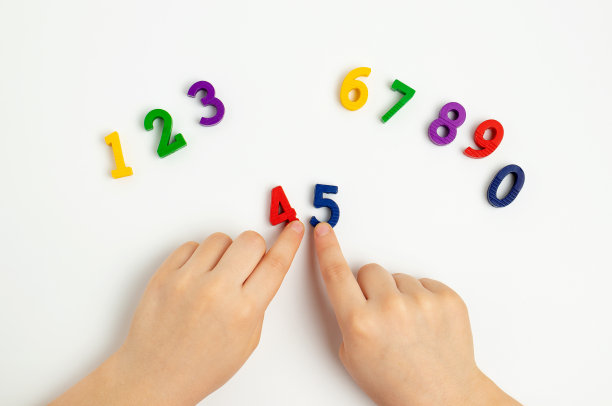 孩子们的手在白色的桌子上移动数字。学习颜色，从0数到10图片下载