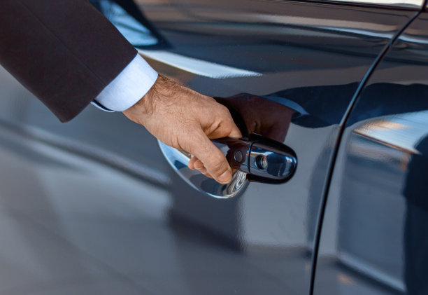 特写一个男性商人的手打开车门在经销店图片下载