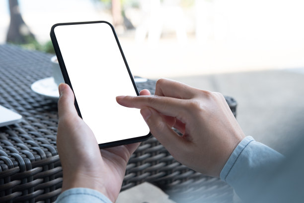 手机空白白屏模型。女子手持手机，在咖啡店用手机打广告图片下载
