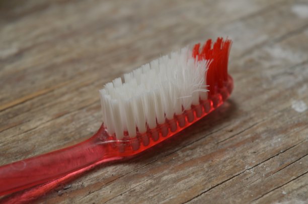 红色塑料柄和白色刷毛的牙刷图片下载