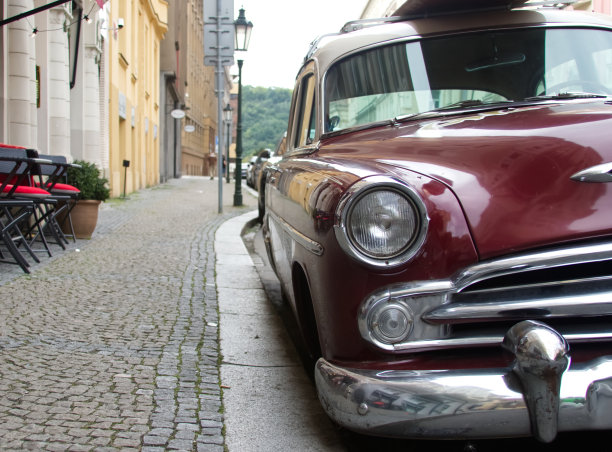 红色复古车停在铺有路面的欧洲街道上特写图片下载
