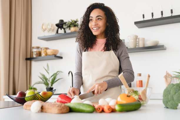 汤沙拉食谱。快乐的年轻非洲厨师，家庭主妇，做饭，准备食物，在家里的厨房，午餐，切蔬菜沙拉。纯素素食概念图片下载