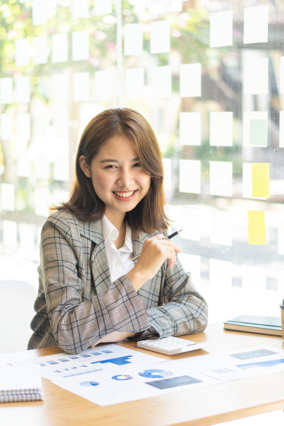 美丽的亚洲妇女微笑愉快地放松使用笔记本电脑在办公室。有创意的年轻女孩工作和打字在键盘上在线工作概念垂直图片图片下载